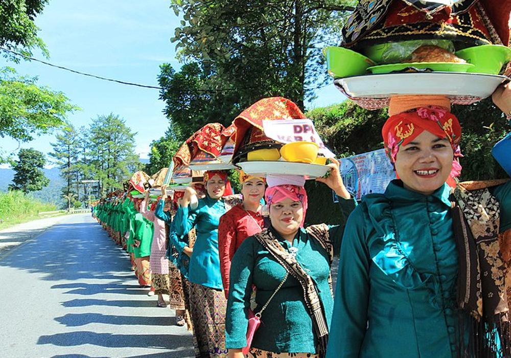 Indonesian women carry food for eating together festival